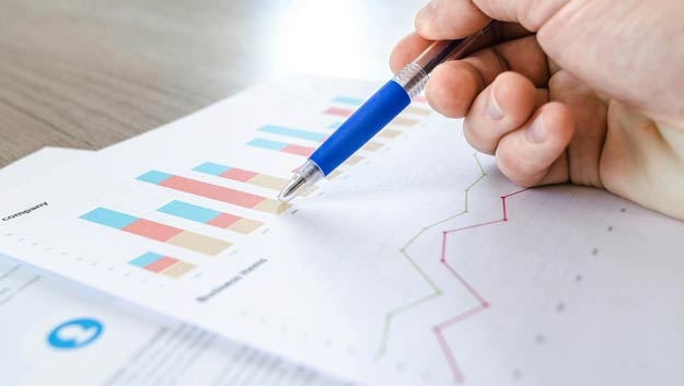 A professional analyzing data charts and graphs on a laptop screen