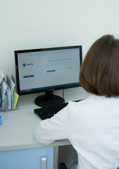 a woman sitting in front of desk while giving exams