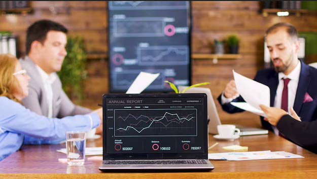 analysts reviewing business data reports from data warehouse for decision making