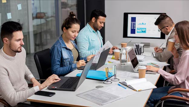 Team managing operations using ERP software in office
